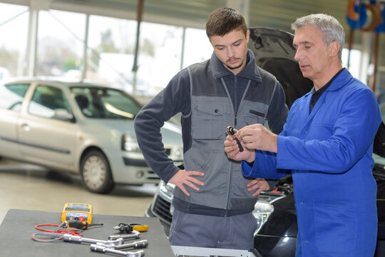 auto mechanic teacher and trainee performing tests at mechanic school