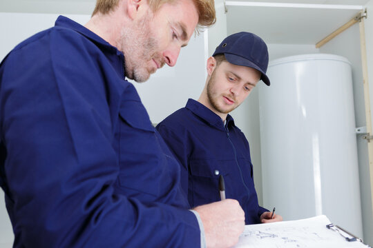 technicians servicing a hot-water heater