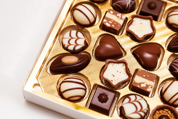 Close up of open small gift box of Swiss chocolate candies. Luxurious selection of milk, dark and...