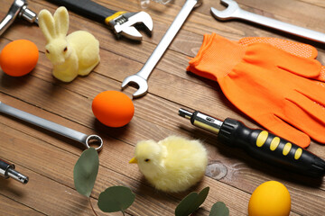 Construction tools with Easter eggs, rabbit and chicken on wooden background, closeup