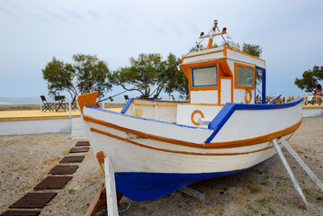 The traditional Greek motor boat is on a beach, Santorini island, Greece - 581931036