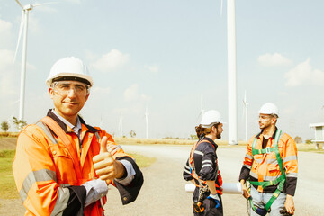 Engineering male technician working together group technicians maintenance team inspecting wind turbines preparing to enter the power station area with thumb up confidently starting work.