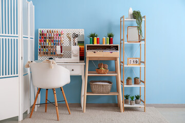 Interior of atelier with tailor's workplace, thread spools and shelving unit