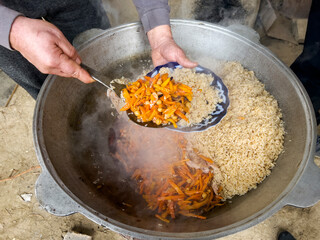 The carrots in the plov are placed on top of the rice.