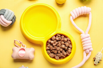 Fototapeta na wymiar Composition with bowl of wet food and pet care accessories on yellow background