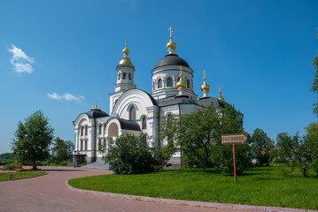 Three domes with crosses (one golden and two green) of the Orthodox Church, blue sky.
