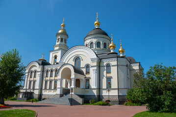 Fototapeta na wymiar Three domes with crosses (one golden and two green) of the Orthodox Church, blue sky.
