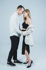 Beautiful young couple in love hugging on a white background. A stylish couple embraces and enjoys feelings. Men and women in stylish casual clothes