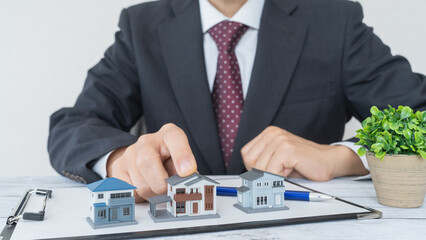 模型の家とスーツの男性