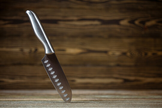 Knife. Stainless steel Knife. Chef or butcher knife. Professional equipment on kitchen. Knife for slice fruit, vegetable, meat. One piece of kitchenware. Cookware set. Table setting. Wooden background