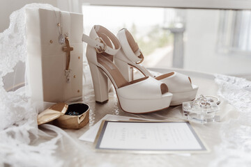 wedding details: bride's shoes, bouquet of flowers, newlyweds vows, rings, earrings, perfume