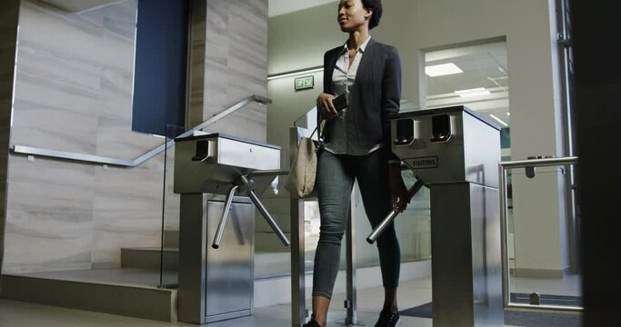 African american businesswomen walking through a turnstile entering an office in slow motion
