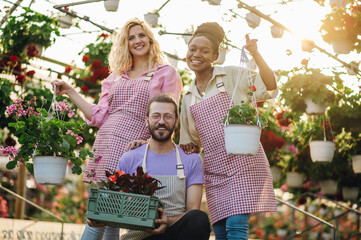 Multiracial group of gardeners working in a greenhouse