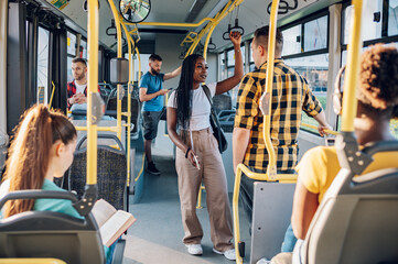 Multiracial friends talking while riding a bus in the city