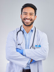 Doctor, man and portrait in a studio with a smile from success, motivation and stethoscope. Happiness, medical consultant and hospital worker with white background smiling about health and wellness