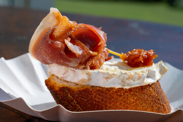 Typical mini burger snack of Basque Country, pinchos or pinxtos, small piece of bread with different toppings, served in bar in San-Sebastian, Spain