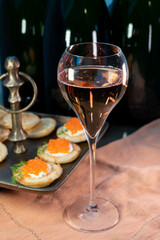 Tasting of rose brut Champagne sparkling wine with red caviar in cellars of gran cru wine house in Epernay, wine tour in Champagne, France
