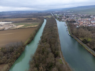 Fototapeta na wymiar Aerial panoramic winter view on cloudy landscape, hilly vineyards and Marne river near Ay gran cru champagne village, wine production in France