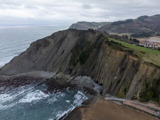 Obraz premium View on steeply-tilted layers of flysch geological formation on Atlantic coast at Zumaia, Basque Country, Spain