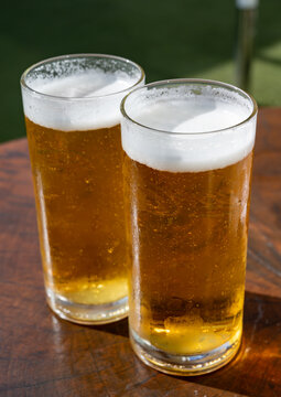 Fresh draught lager or IPA beer is glass served in outdoor cafe close up, pint of beer close up