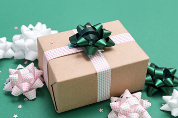 Gift box with bows and stars on green background, closeup