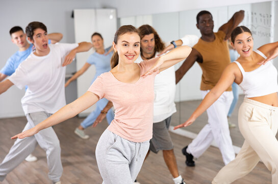 Group of energetic different people learning dance at dance class