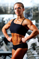Fototapeta premium Young sports woman posing in gym