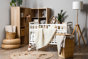 Interior of children's bedroom with baby crib and shelving unit