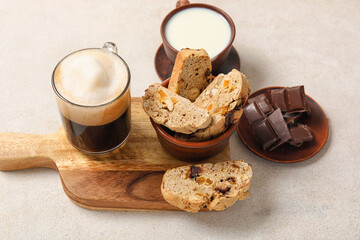 Delicious biscotti cookies, glass of coffee and cup of milk on white grunge background