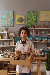 Fototapeta premium Smiling Woman working in home decor studio with elements of interior decorations