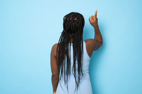 Young african american woman wearing casual dress standing over isolated blue background Posing backwards pointing ahead with finger hand