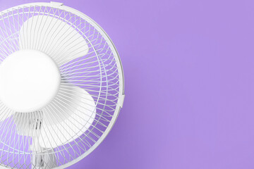 Electric fan on lilac background