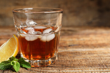 Glass of rum on wooden background, closeup