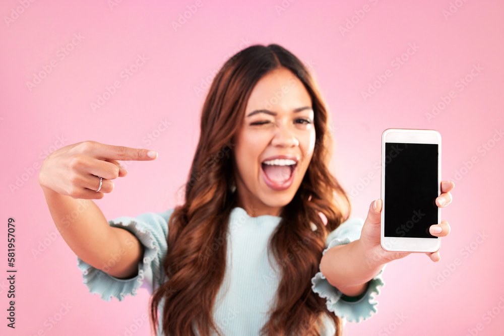 Poster Phone screen, wink and woman pointing to mockup in studio isolated on pink background. Cellphone, face portrait or happy female with mobile smartphone for advertising, marketing or product placement.