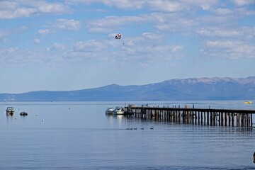 Parasailers and boaters begin their mornings on the peaceful waters of Lake Tahoe in the Sierra...