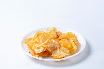 Potato chips on a white plate isolated on a white background.