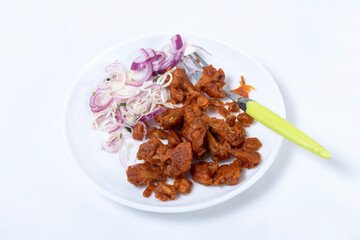 Fried Gobi Manchurian with red onion and fork on a white plate isolated on white background.