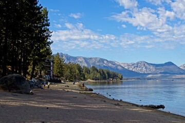 Parasailers and boaters begin their mornings on the peaceful waters of Lake Tahoe in the Sierra...