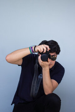 Persona con pulseras artesanales tomando una foto de manera profesional y vestido con colores oscuros