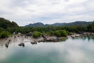 Local fishing pier, Andaman coast of Thailand. fisherman harbor. Fishing boats of villagers Parked at pier. aerial view, top view.