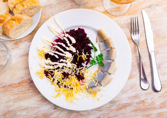 Delicious boiled beetroot with grated cheese and slices of lightly salted herring, sprinkled with...