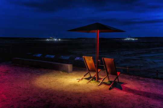 Umbrellas at the viewpoint of the Hambach brown coal mine at night, in Elsdorf, Germany