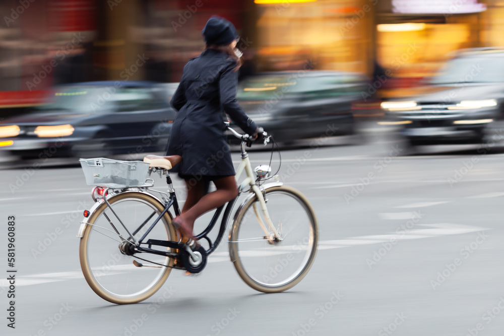 Wall mural woman riding a bicycle on a city street