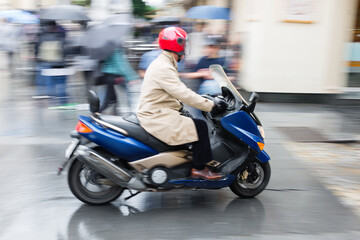 man with a scooter driving in the city