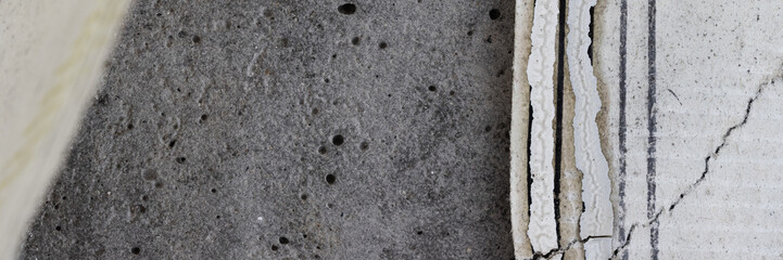 Torn old faded paper wallpaper with a retro pattern. Tattered scraps of paper on a concrete wall. Vintage texture for background and design. Closeup view with copy space.