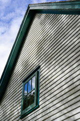 A vintage style two-story building. The vernacular structure is clad in cape cod clapboard with...