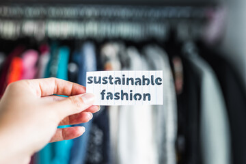 ethical practices in the fashion industry, Sustainable Fashion held in front of wardrobe full of...