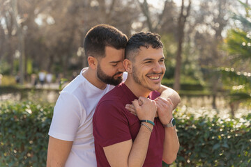 gay couple in the park, cuddling, loving and playful