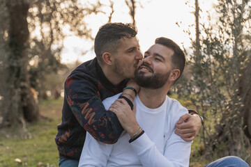 Fototapeta premium gay couple in the park, cuddling, loving and playful