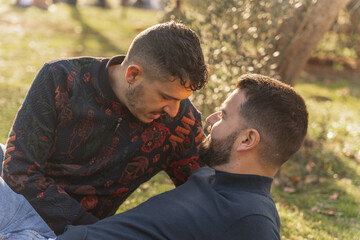 gay couple in the park, cuddling, loving and playful